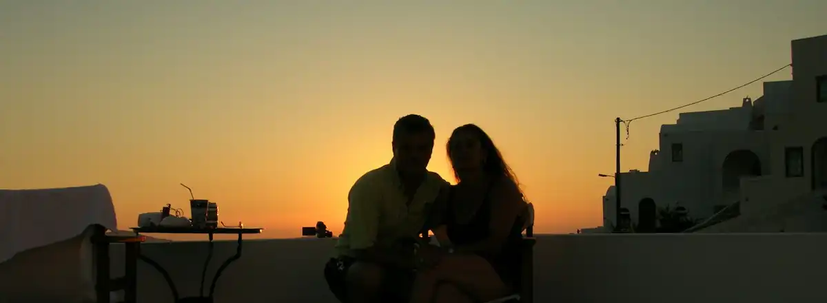 Un couple au balcon au coucher du soleil